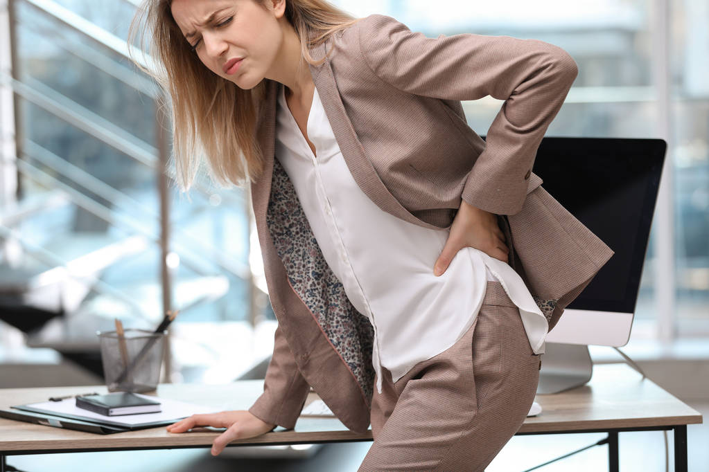 Młoda kobieta cierpiąca na ból pleców w biurze - Zdjęcie, obraz