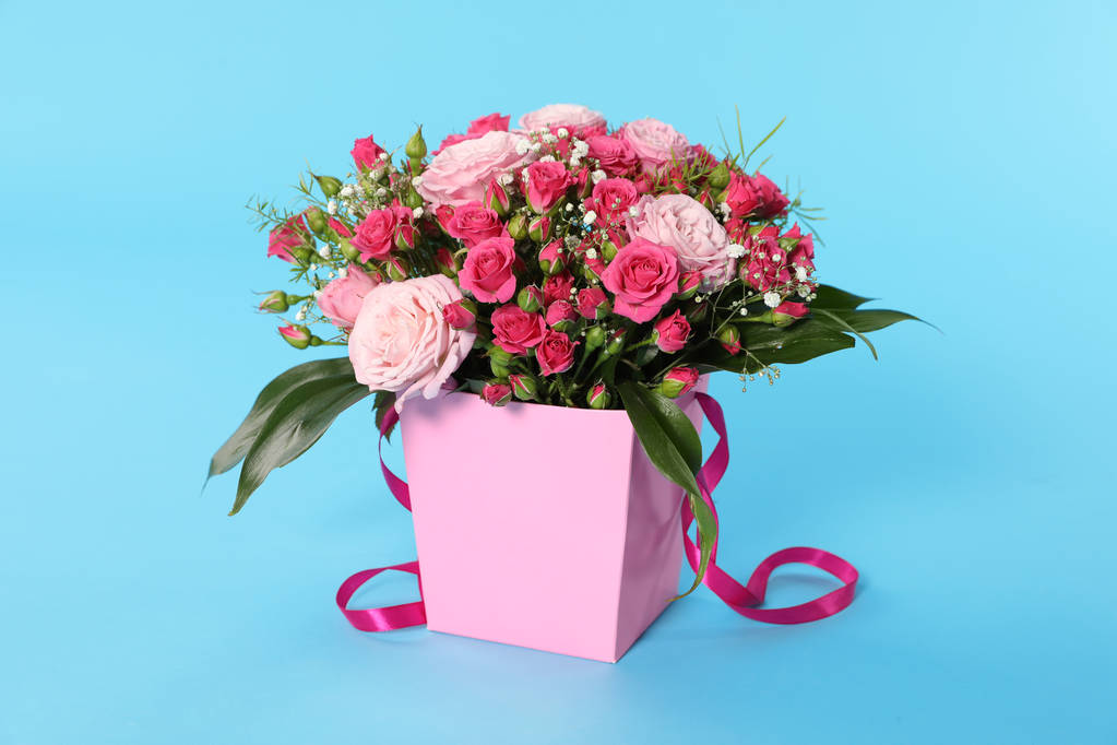 Beautiful bouquet of flowers in paper gift box on color background - Photo, Image