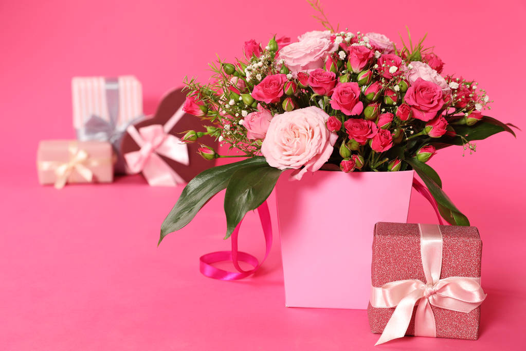 Composition with beautiful bouquet and gift boxes on color background - Photo, Image