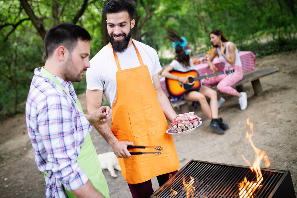 Amis faisant une fête barbecue dans la nature tout en s'amusant - Photo, image