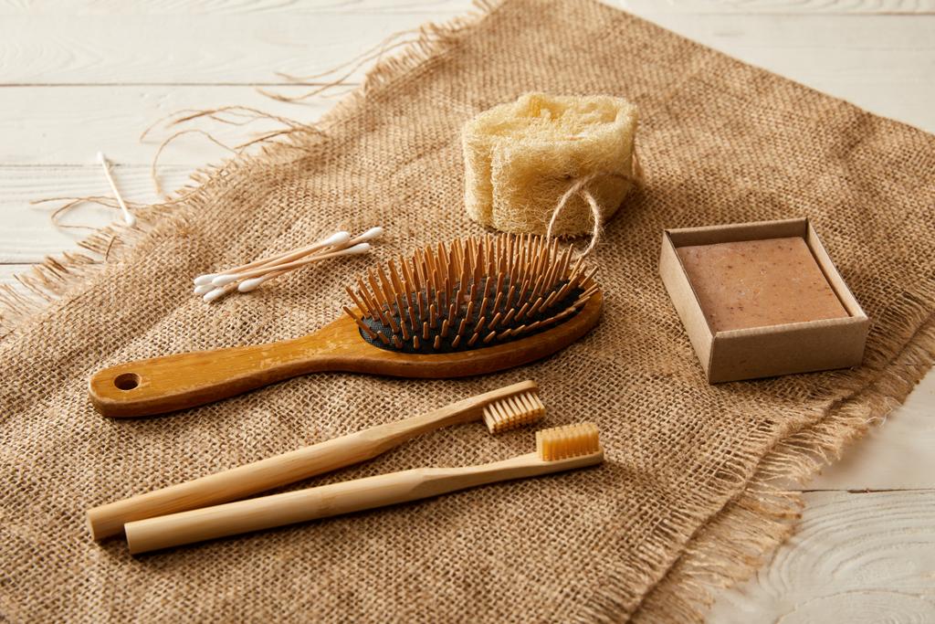different hygiene and care items on sackcloth on white wooden surface, zero waste concept - Photo, Image