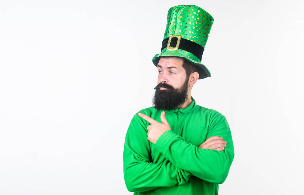 ハッピー聖パトリックの日。ひげを生やした男はセント ・ パトリックス ・ デーを祝います。緑のレプラコーンの帽子と衣装の流行に敏感。彼の指を指しているひげのアイルランド人。あそこを見て、空間をコピー - 写真・画像