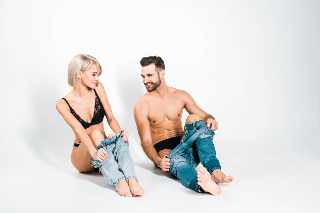 handsome smiling man and happy woman wearing jeans on grey - Photo, Image