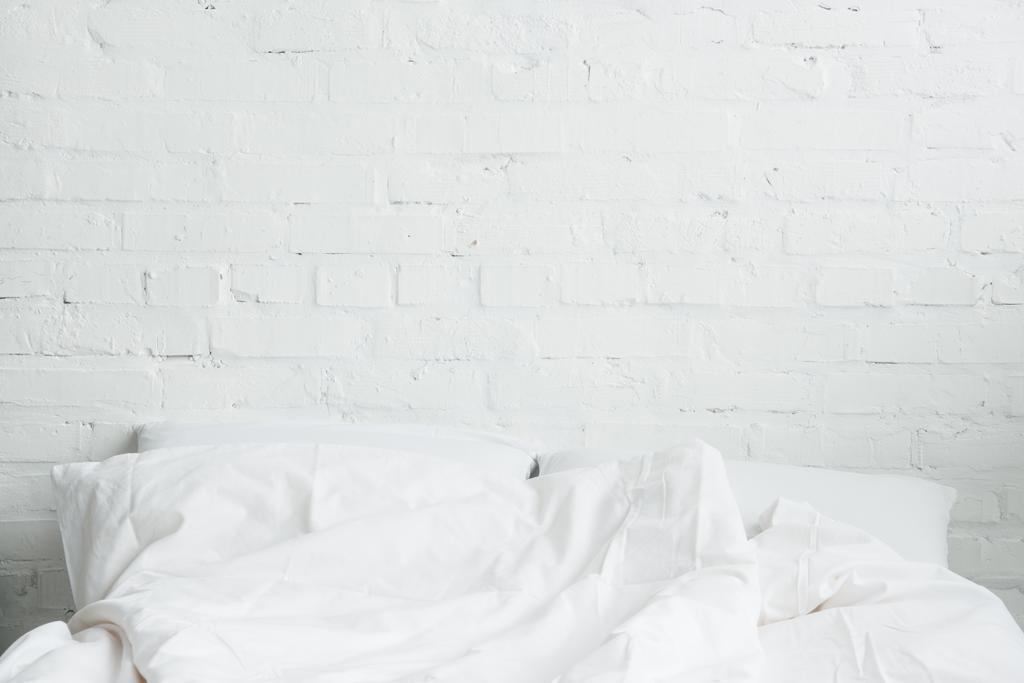 Cama vacía y acogedora con almohadas blancas y manta
  - Foto, imagen