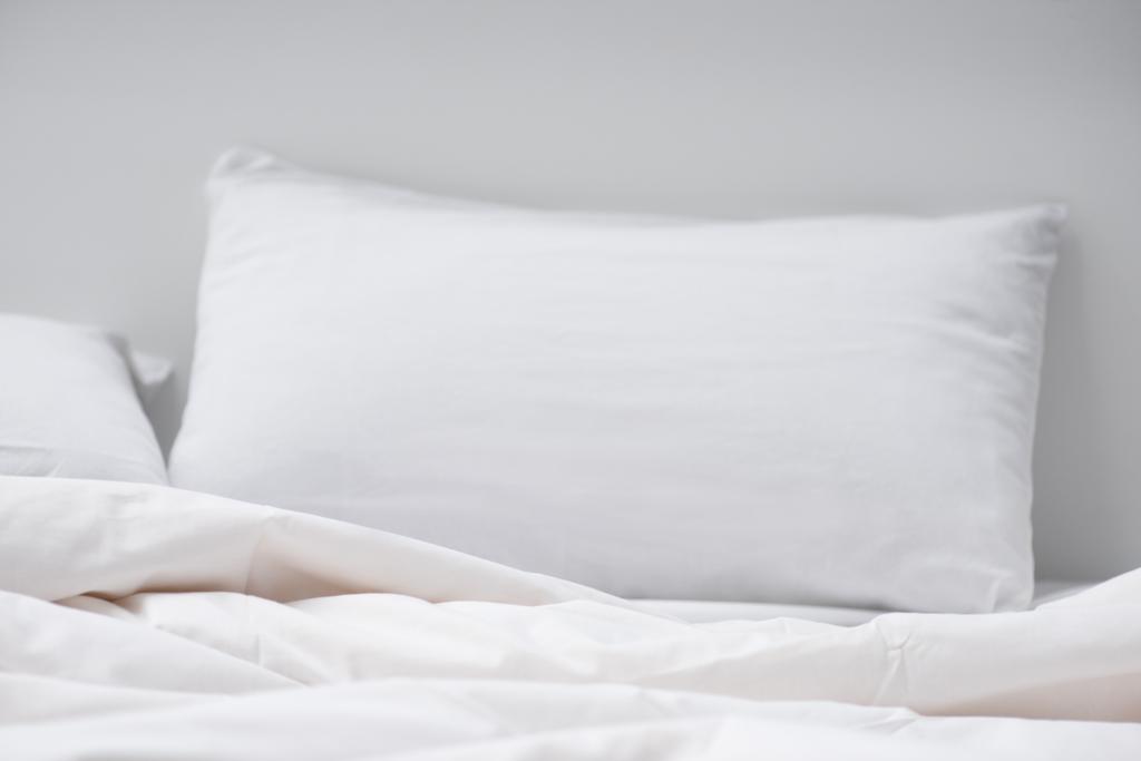 foco seletivo da cama com travesseiro branco e cobertor
  - Foto, Imagem