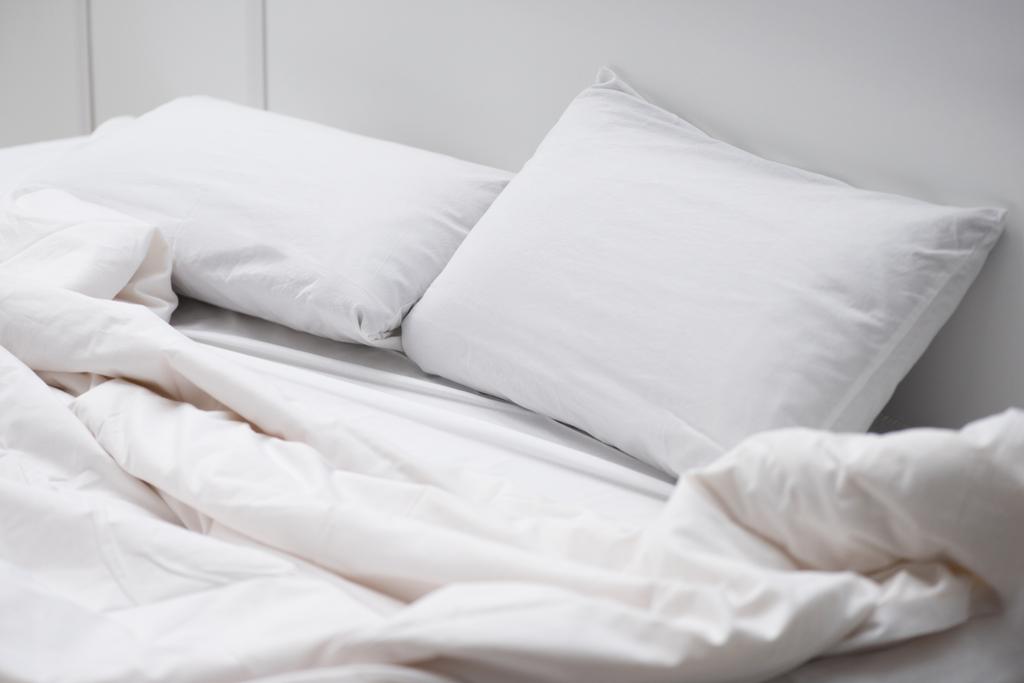 cama vacía con almohadas blancas y manta
  - Foto, Imagen