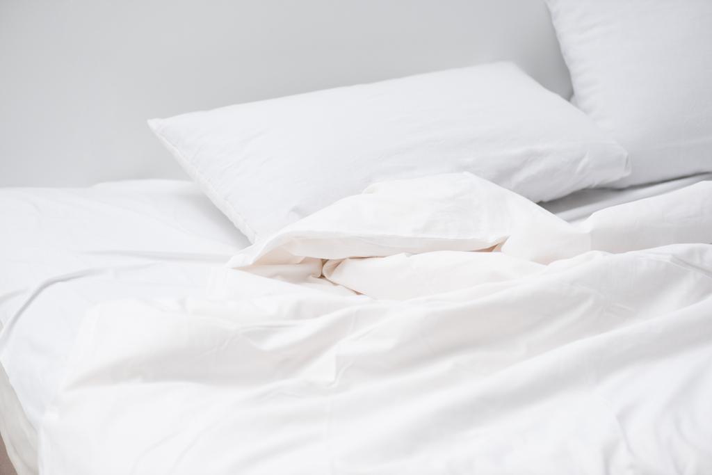 白い枕と毛布が付いている居心地の良いベッド ロイヤリティフリー写真 画像素材