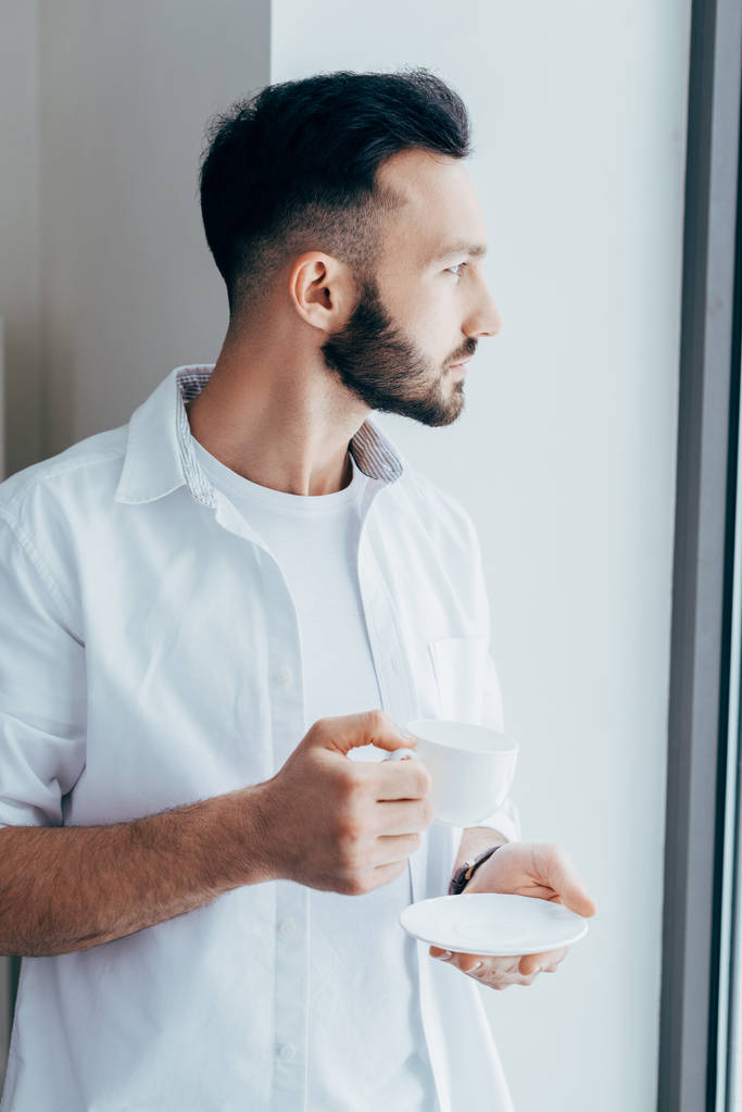 Zamyšlený mladý muž s plnovousem pití kávy - Fotografie, Obrázek