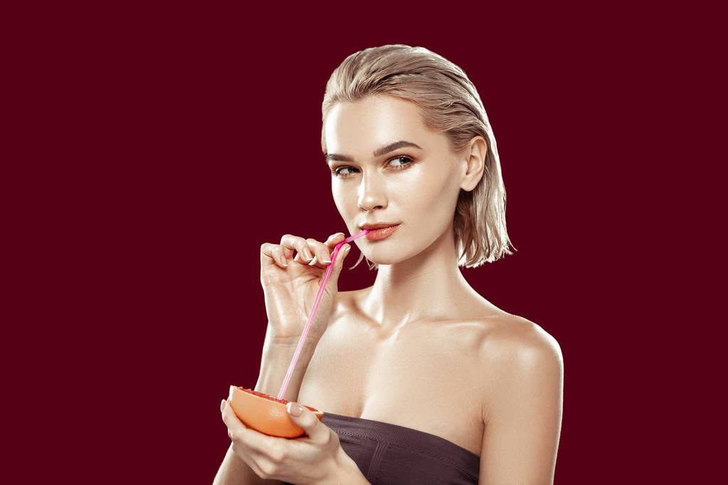 Model s krátkými blond vlasy pít grapefruitový džus - Fotografie, Obrázek