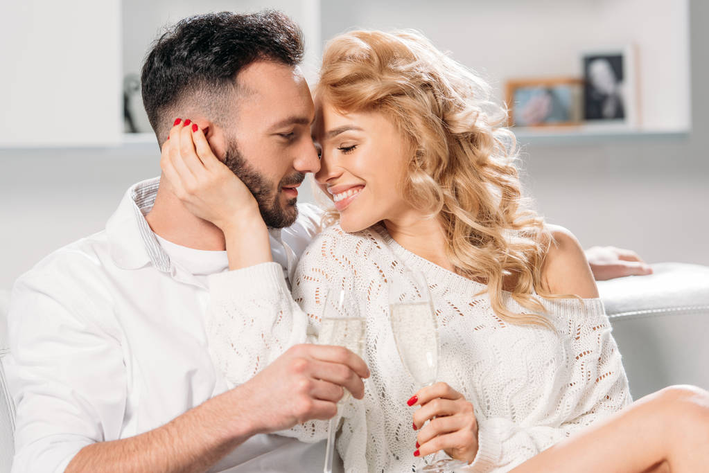 Blissful smiling couple drinking champagne at home - Photo, Image