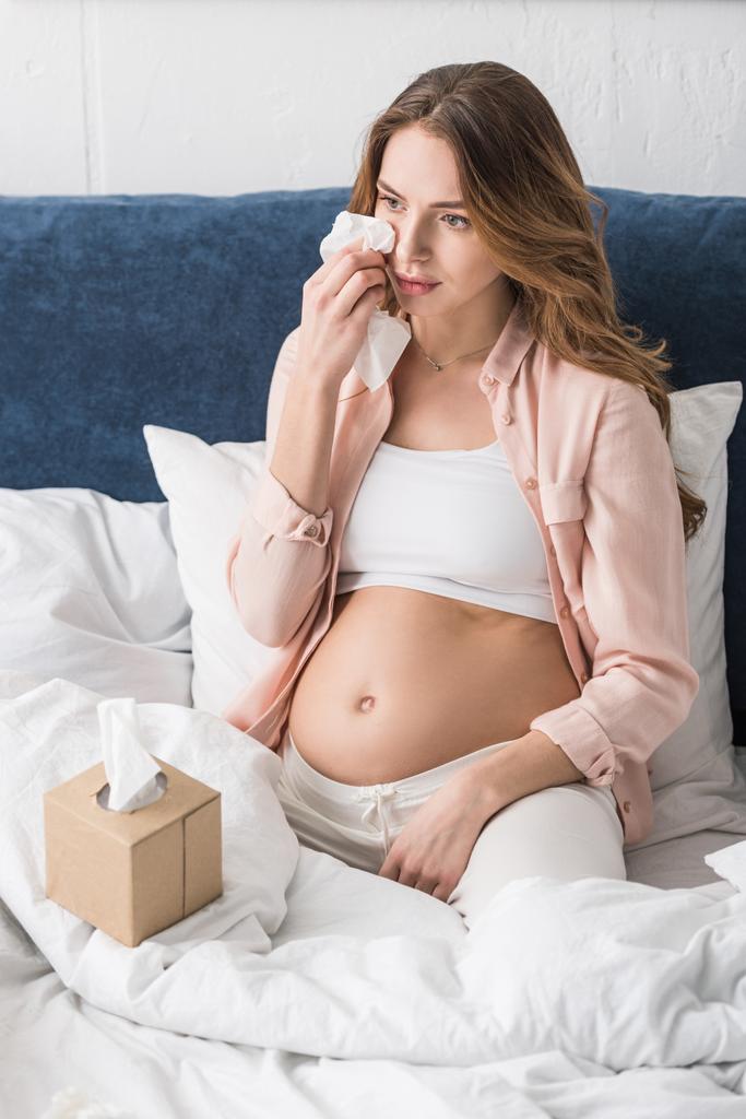 Triste enceinte jeune femme essuyant des larmes avec serviette
 - Photo, image