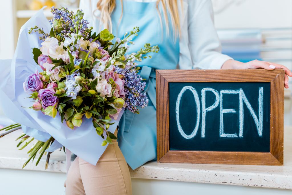 női virág üzlet tulajdonosa gazdaság Palatábla a "Megnyitás" betűk és színes csokor vágott látképe - Fotó, kép