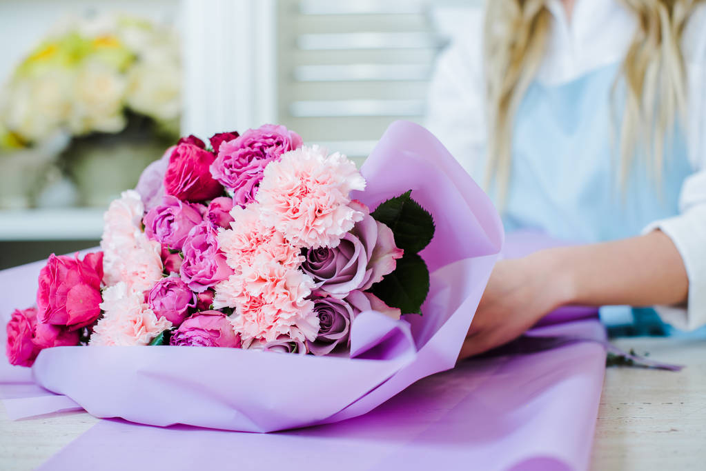περικοπεί προβολή της γυναικείας ανθοπωλείο τακτοποίηση ανθοδέσμη με ροζ τριαντάφυλλα και γαρίφαλα - Φωτογραφία, εικόνα