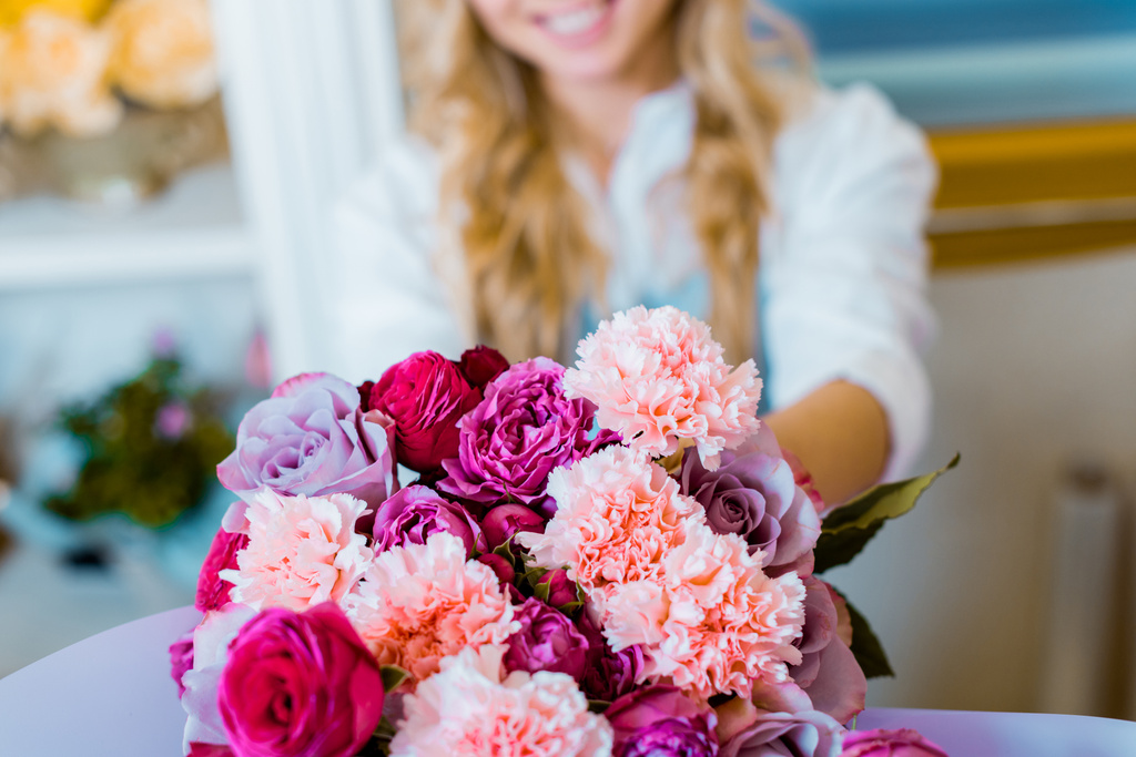 vue partielle de la femme tenant un bouquet de fleurs avec des roses et des œillets
 - Photo, image