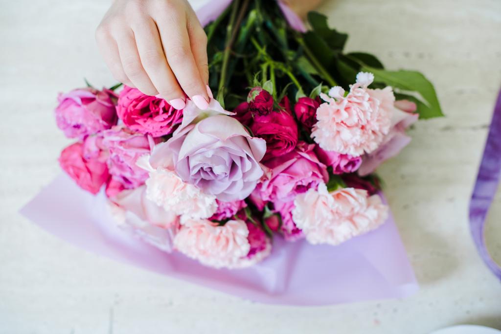 Nézd a női virágüzlet megszervezése csokor rózsaszín rózsa és a szegfű vágott - Fotó, kép
