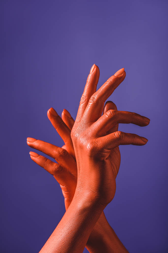 részleges kilátás nő korall színű kezek lila háttér, szín, 2019 fogalom - Fotó, kép
