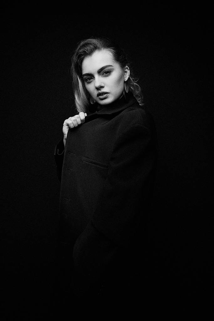  Красива молода жінка позує в чорній куртці
                 - Фото, зображення