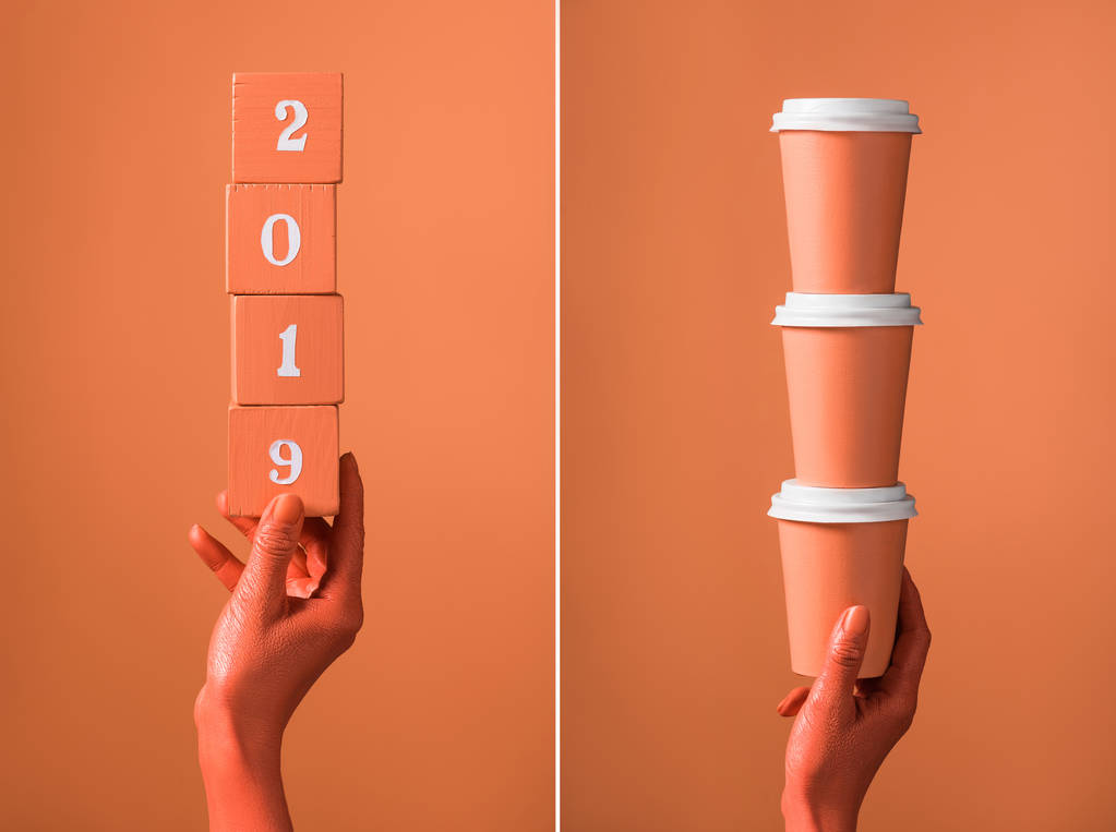 cubes en bois de corail avec numéros 2019 et pile de tasses en papier de corail dans les mains des femmes sur fond de corail divisé, couleur du concept 2019
 - Photo, image