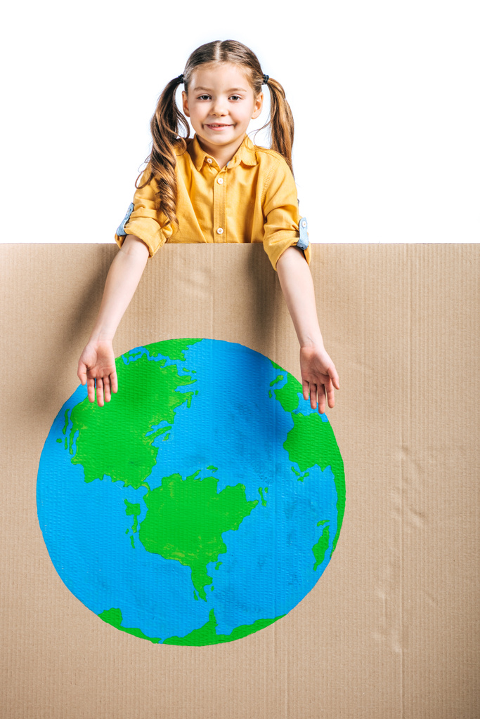 cute smiling child pointing at globe sign on cardboard placard isolated on white, earth day concept - Photo, Image