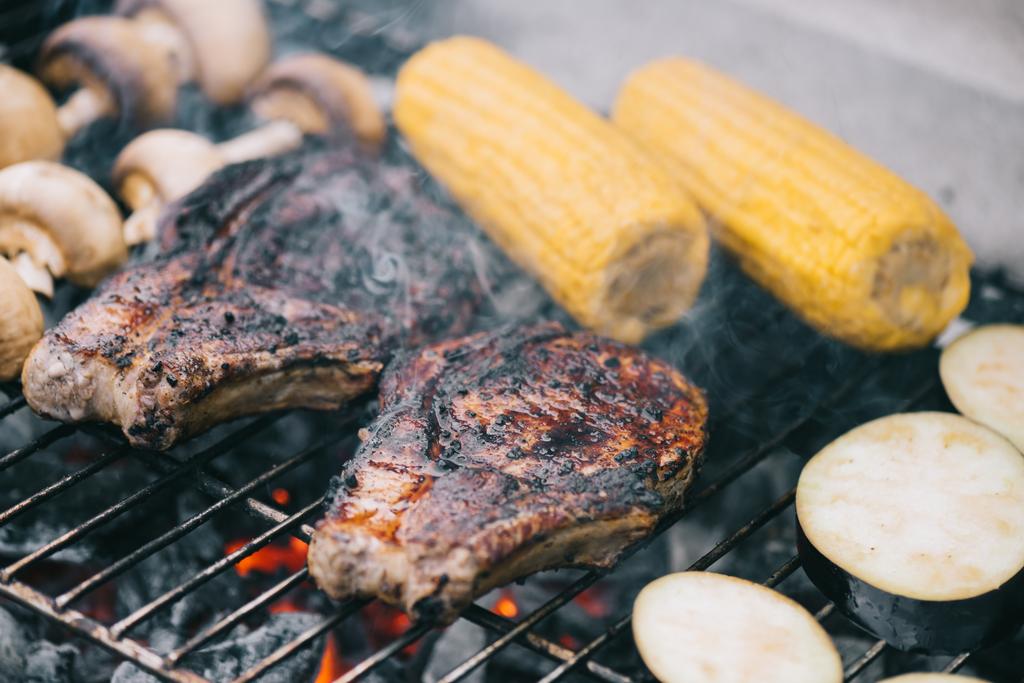 foyer sélectif de steaks juteux et savoureux grillades sur grille de barbecue aux champignons, maïs et aubergines tranchées
 - Photo, image