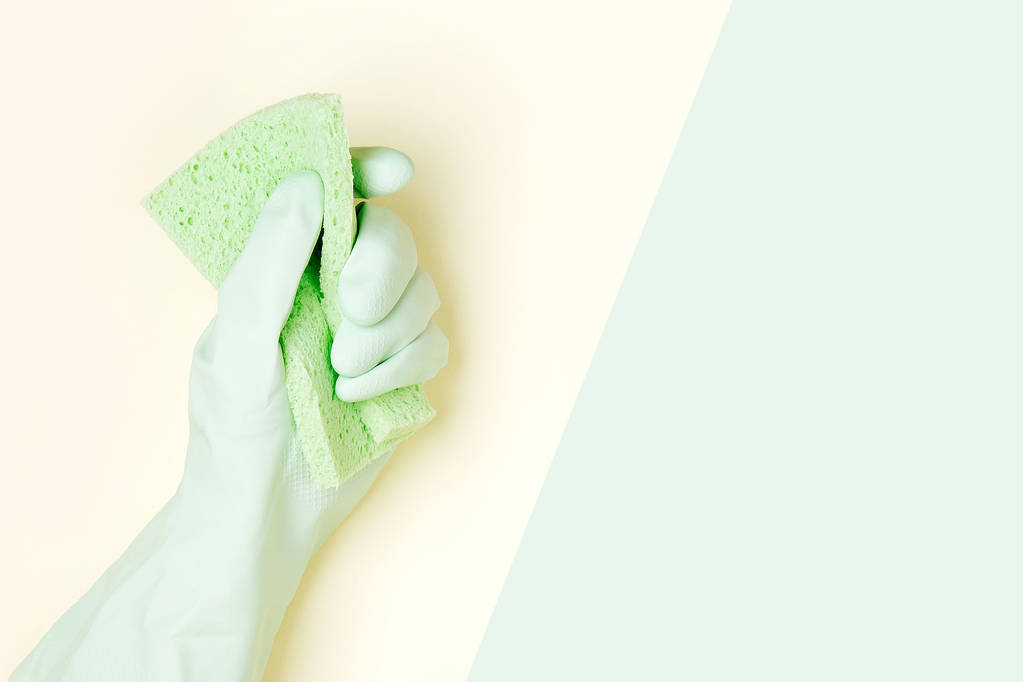 Female hand cleaning on yellow and green background, housekeeping concept background - Photo, Image