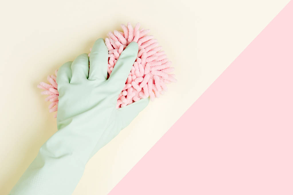 Female hand cleaning on yellow and pink background, housekeeping concept background - Photo, Image