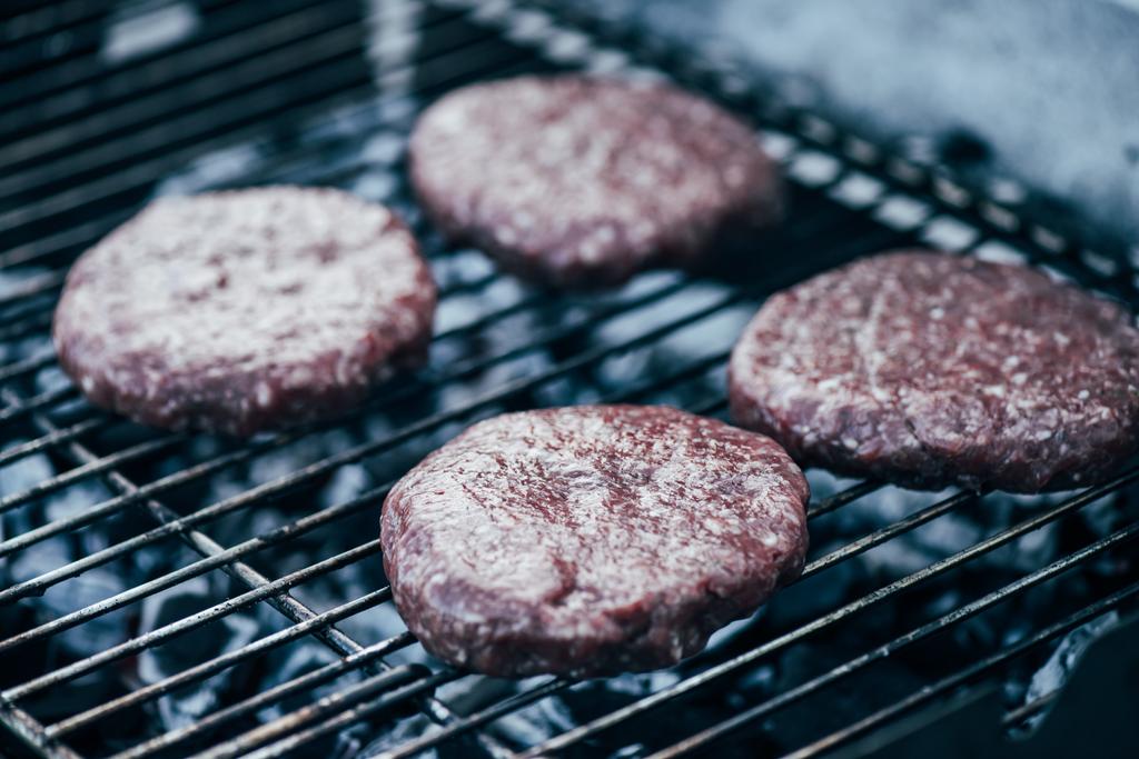uncooked fresh burger cutlets grilling on bbq grid - Photo, Image