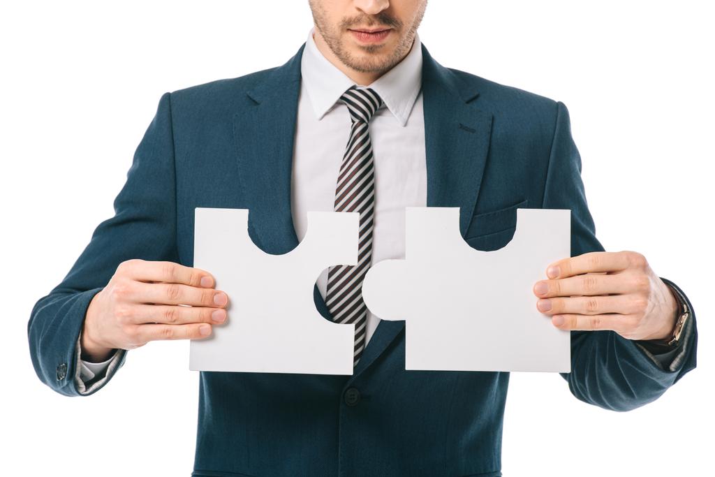 cropped view of businessman holding puzzle pieces isolated on white, business solution concept - Photo, Image