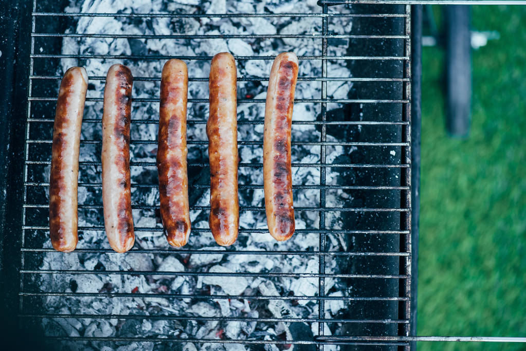 vue de dessus de savoureuses saucisses grillées sur barbecue grill grade sur fond d'herbe verte
 - Photo, image