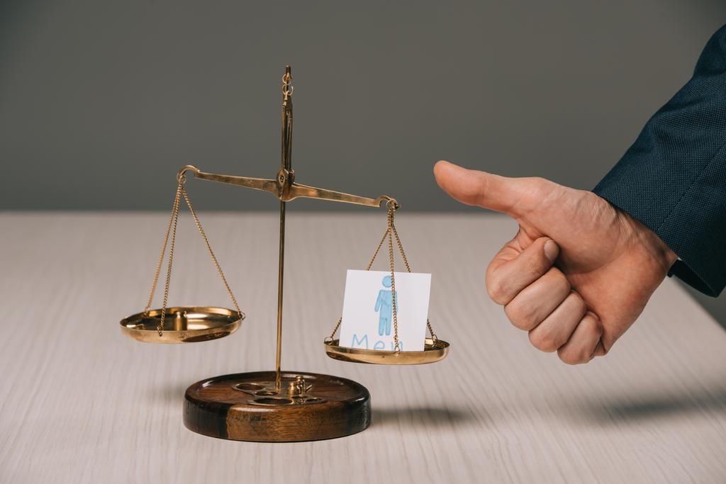 partial view of businessman showing thumbs up near scales of justice and male signs, gender stereotypes concept  - Photo, Image