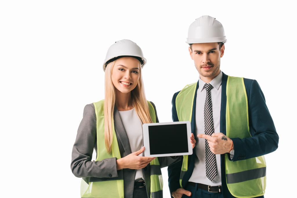 architects in safety vests and hardhats showing new project on digital tablet, isolated on white - Photo, Image