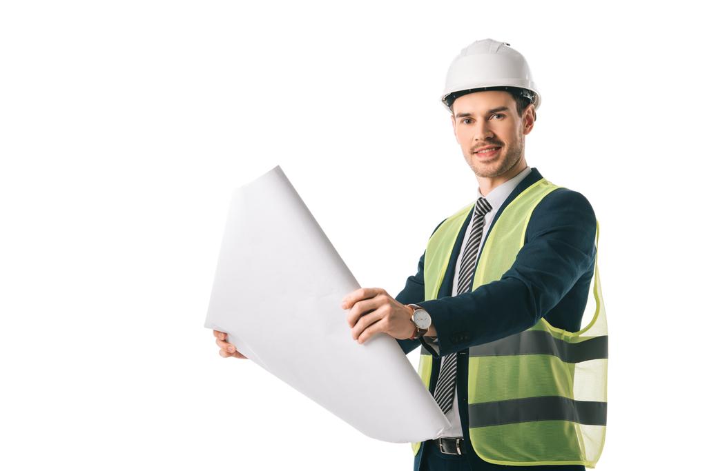 glimlachend mannelijke architect in helm en veiligheid vest bedrijf blauwdruk, geïsoleerd op wit - Foto, afbeelding