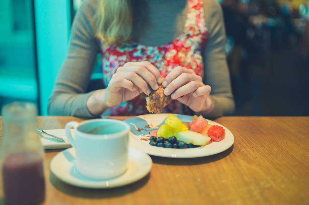 健康的な朝食の果物とコーヒーを持っている若い女性 - 写真・画像