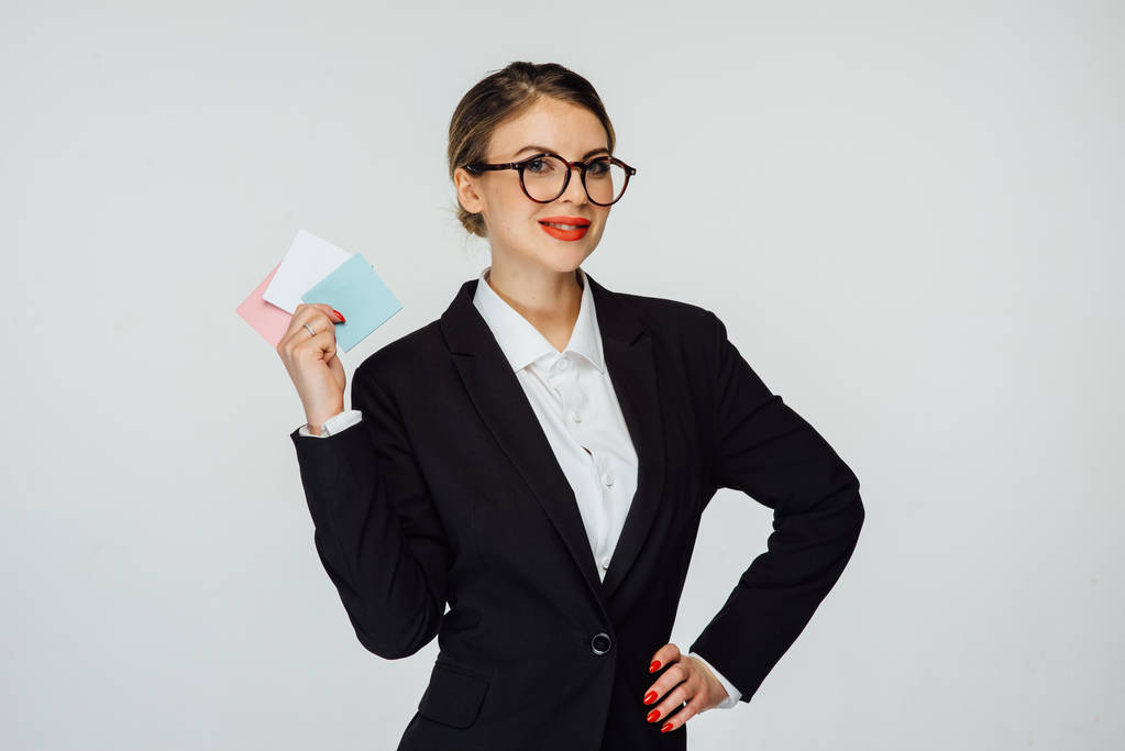 sexy mujer de negocios en gafas y en traje moderno está de pie sobre un fondo blanco
 - Foto, imagen