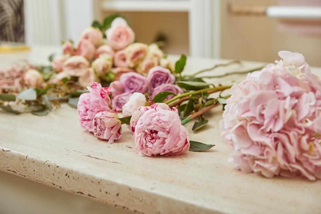 vaaleanpunaisten ruusujen ja pionien valikoiva painopiste pinnalla
 - Valokuva, kuva