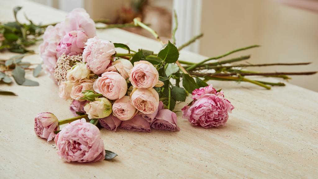  buquê com rosas e peônias na mesa na loja de flores
 - Foto, Imagem