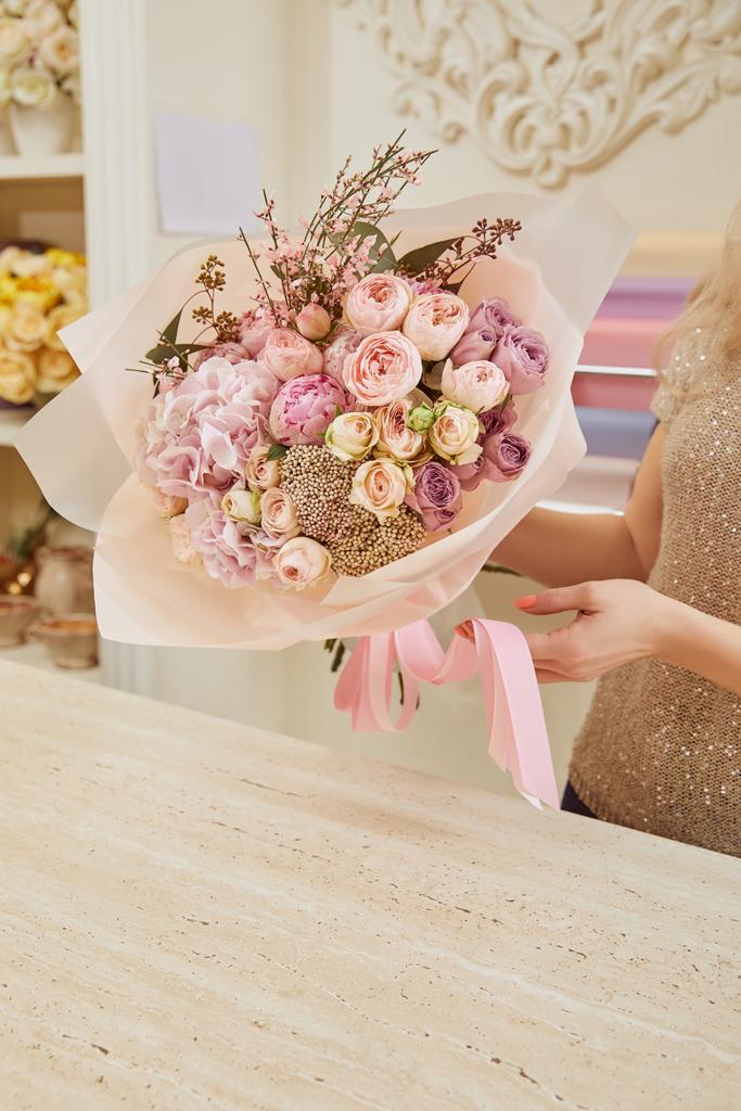 vista parcial de floristería con ramo de rosas y peonías
  - Foto, imagen