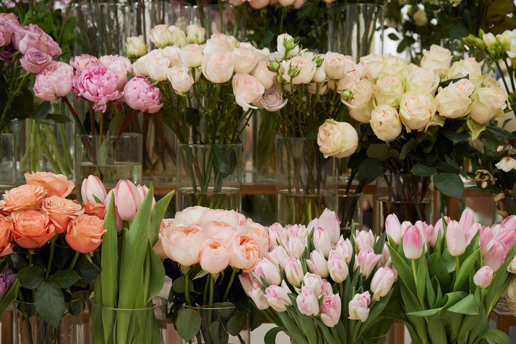 ruusut, tulppaanit ja pionit lasimaljoissa
 - Valokuva, kuva