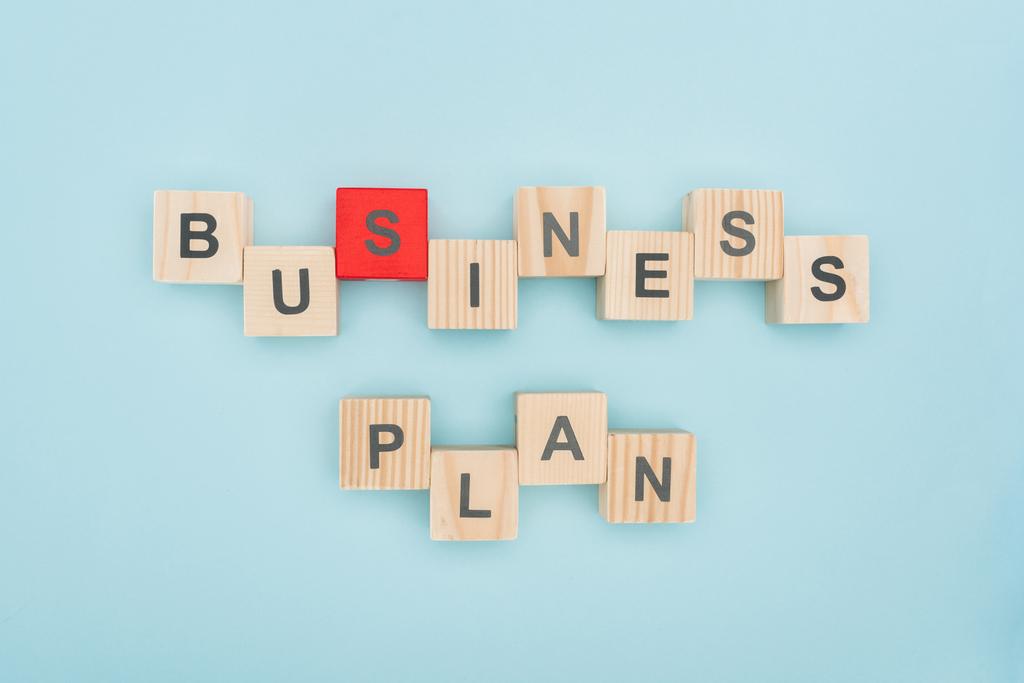 Draufsicht auf Businessplan-Schriftzug angeordnet aus Holzwürfeln auf blauem Hintergrund - Foto, Bild