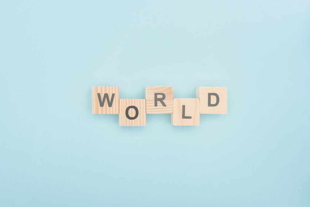 Weltschrift von oben aus Holzwürfeln auf blauem Hintergrund - Foto, Bild