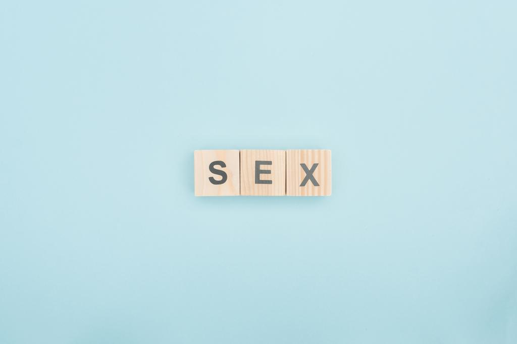 vista superior de letras de sexo hechas de cubos de madera sobre fondo azul
 - Foto, Imagen