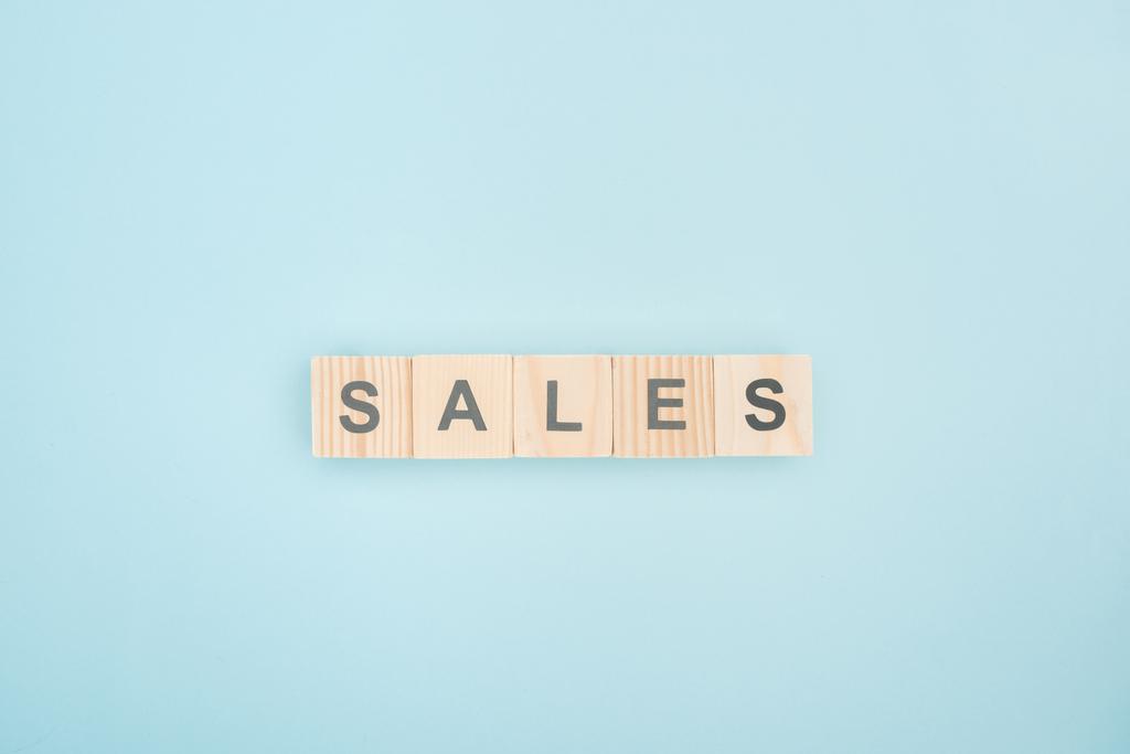 top view of sales lettering made of wooden cubes on blue background - Photo, Image