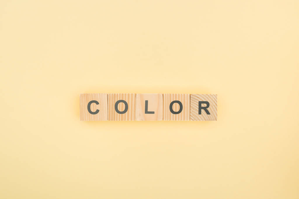 вид зверху кольорового написання з дерев'яних кубиків на жовтому фоні
 - Фото, зображення