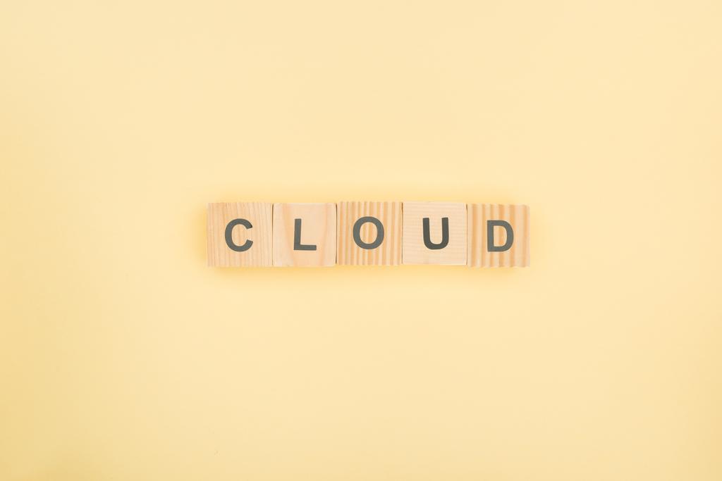 top view of cloud lettering made of wooden cubes on yellow background - Photo, Image