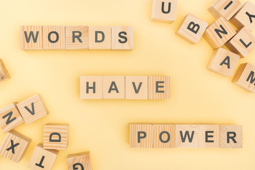 top view of phrase words have power lettering with wooden cubes on yellow background - Photo, Image