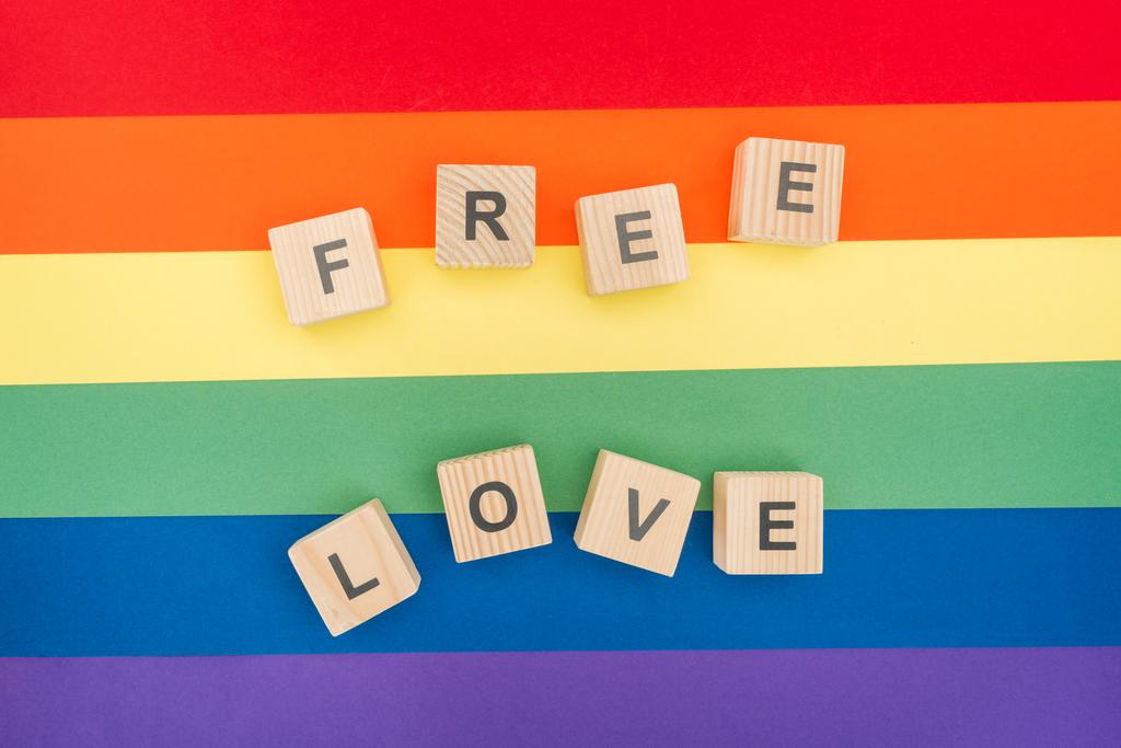 vista dall'alto del lettering amore libero fatto di cubi di legno su sfondo arcobaleno di carta
 - Foto, immagini