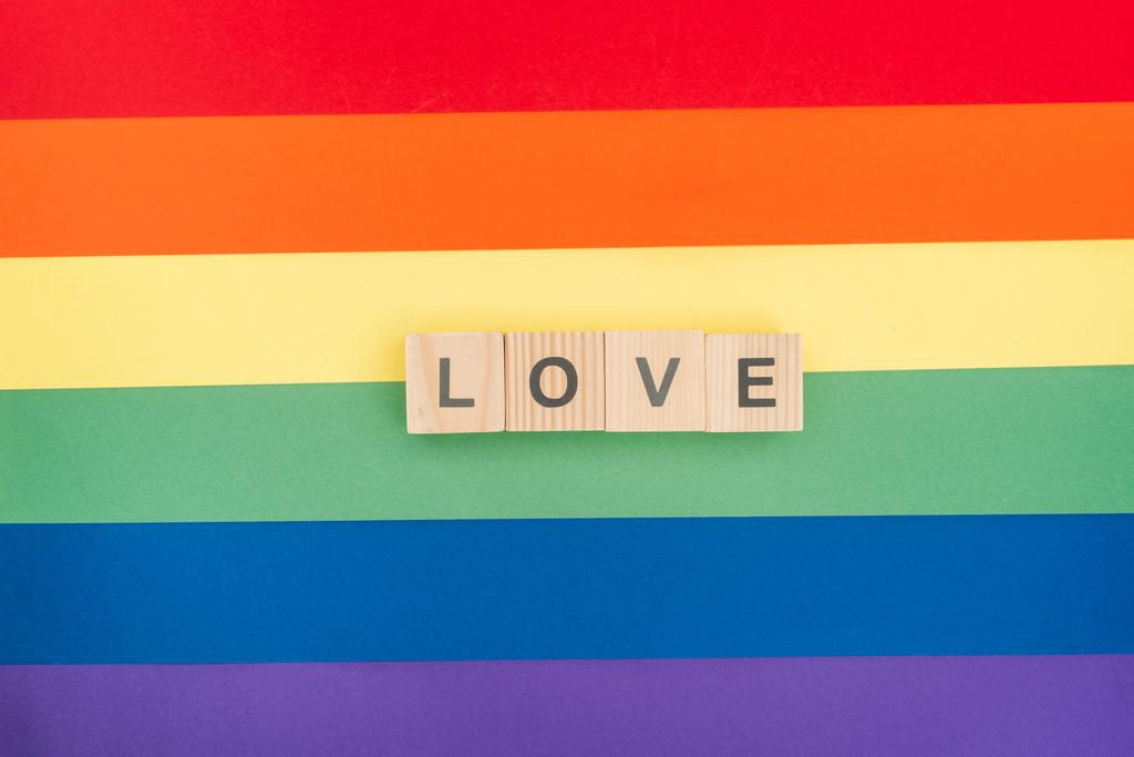 vista superior do amor lettering feito de blocos de madeira sobre papel arco-íris fundo
 - Foto, Imagem
