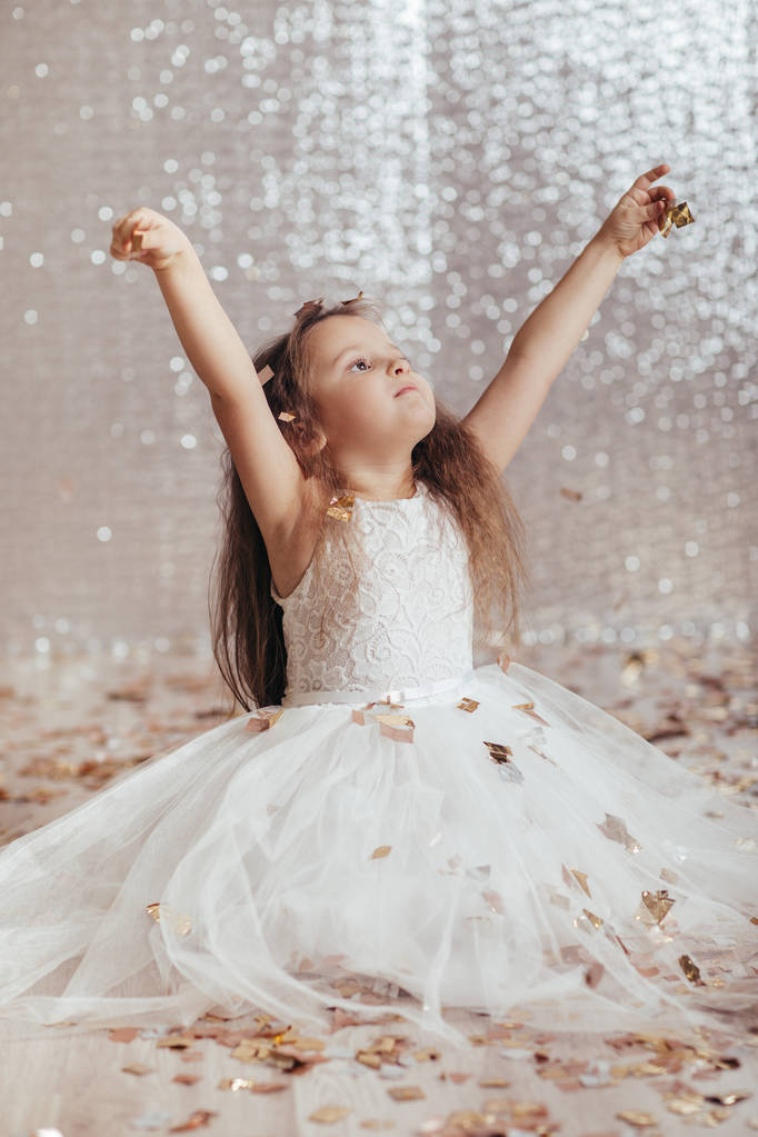 μικρό παιδί κορίτσι πριγκίπισσα φόρεμα σε φόντο κομφετί - Φωτογραφία, εικόνα