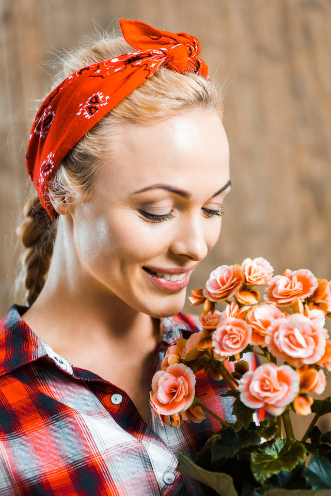 fröhliche Frau mit geschlossenen Augen und duftenden Blumen - Foto, Bild