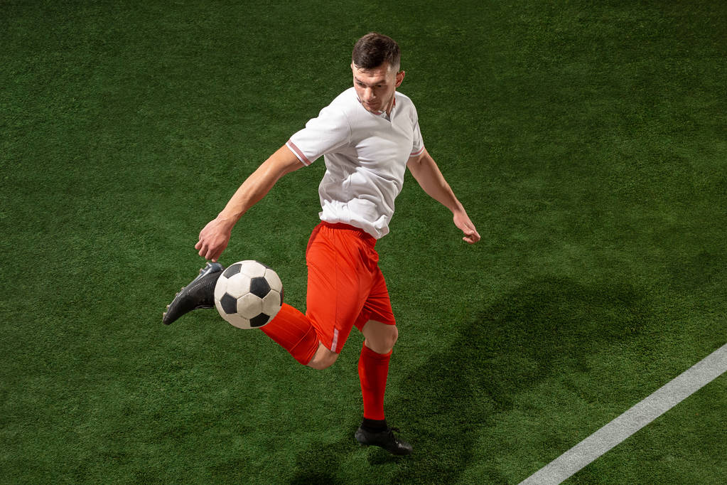 Piłka nożna gracz walki piłkę ponad zielona trawa tło - Zdjęcie, obraz
